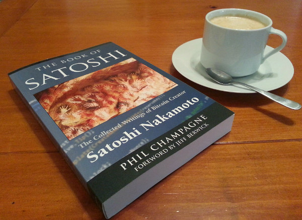 Photo of a softcover copy of the book next to a cup of coffee