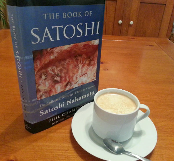 Photo of a hardcover copy of the book next to a cup of coffee